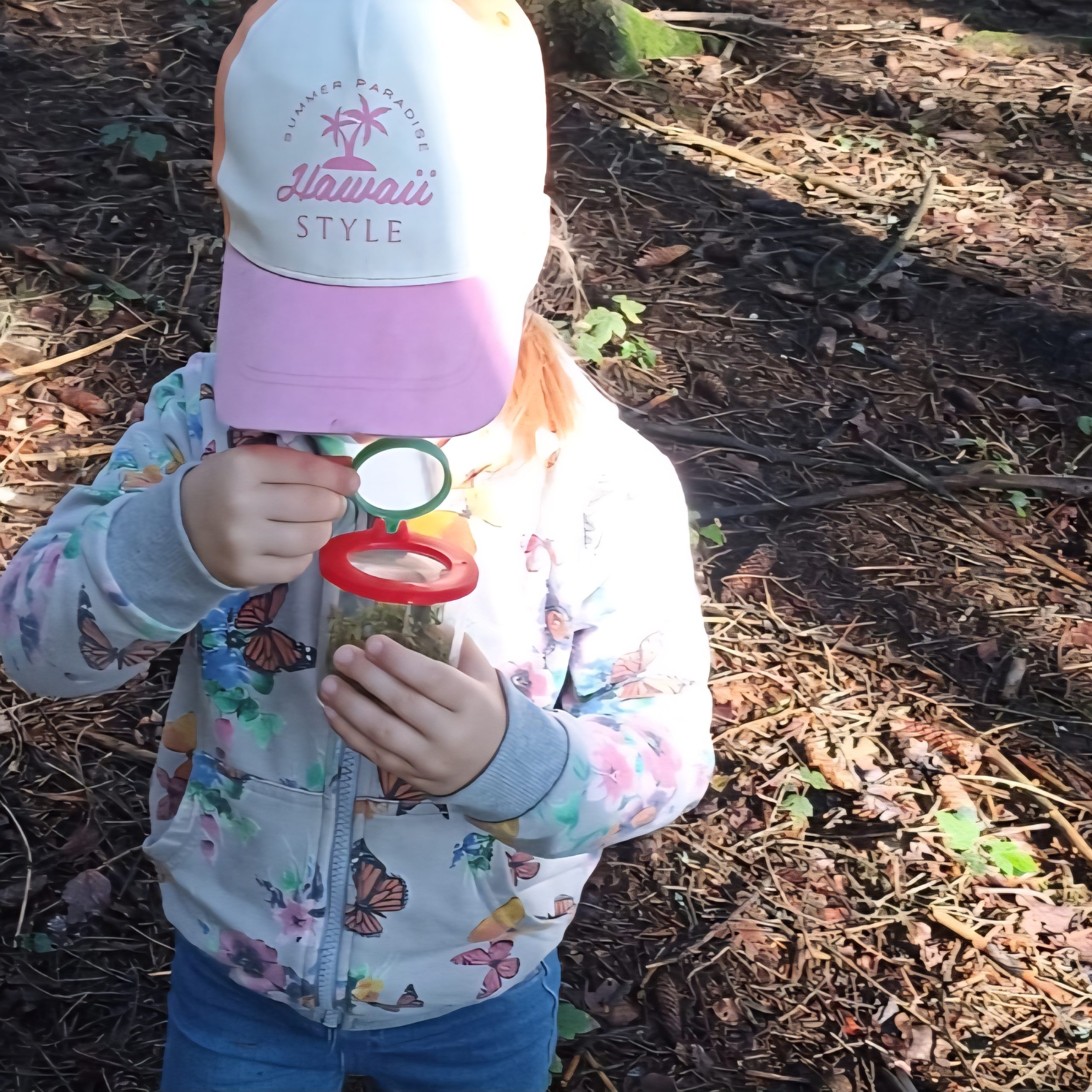 Unsere Waldtage im Kindergarten  Kind schaut in Vergrößerungsglas