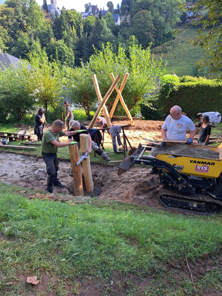 In 4 Elterneinsätzen gelang es uns, eine 7 Meter lange Rutsche, 19 Robinen Stämme mit bis zu 5 Meter Länge, einen Rutschen Aufstieg, der 7 Meter lang ist, und Tonnen von Beton und Sand mit Schubkarren und Minibagger an Ort und Stelle zu bringen.