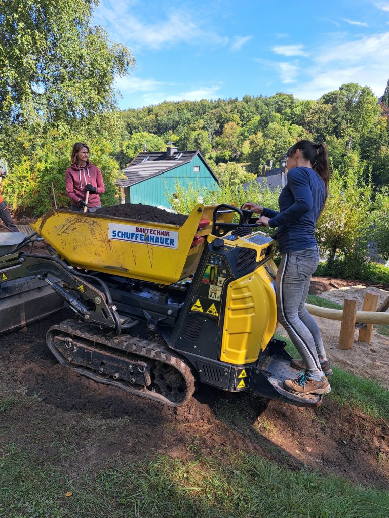 In 4 Elterneinsätzen gelang es uns, eine 7 Meter lange Rutsche, 19 Robinen Stämme mit bis zu 5 Meter Länge, einen Rutschen Aufstieg, der 7 Meter lang ist, und Tonnen von Beton und Sand mit Schubkarren und Minibagger an Ort und Stelle zu bringen.