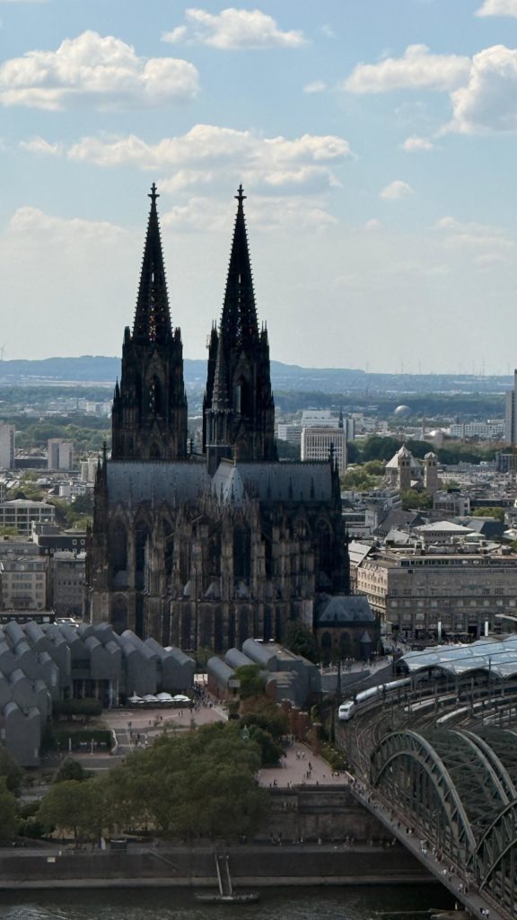 Ein wirklich sonniger und sehr heißer Tag. Weit weg wollten wir uns bei den Temperaturen nicht bewegen. Aber in unmittelbarer Nachtbarschaft unserer Herberge befindet sich ein Aussichtsturm, der „Cologne View“. Ein sehr schneller Fahrstuhl brachte uns in die 28. Etage und wir hatten einen
wunderbaren Blick auf den Rhein und ganz Köln. Wir konnten diesen Moment wirklich genießen und entschieden uns noch an dieser Aussichtsstelle zu verweilen.